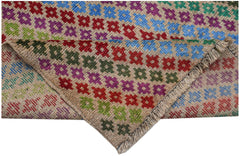 Handmade Afghan Pashm rug featuring a geometric floral pattern in vibrant colors on a tan base.