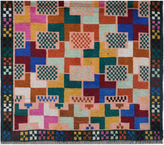 Handmade Afghan Pashm rug featuring a colorful geometric grid pattern on a light pink background.