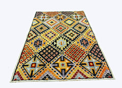 Hand-knotted Afghan wool rug featuring a vibrant geometric diamond pattern in multi-colored tones.