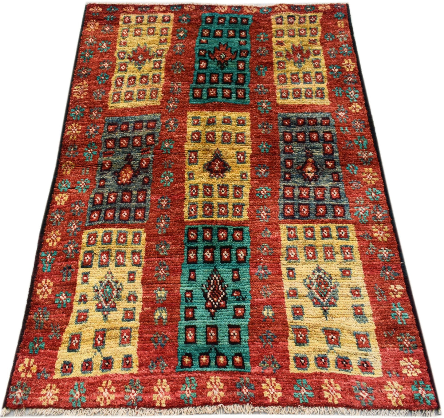 Hand-knotted Afghan wool rug featuring a red background with geometric yellow and teal panels.