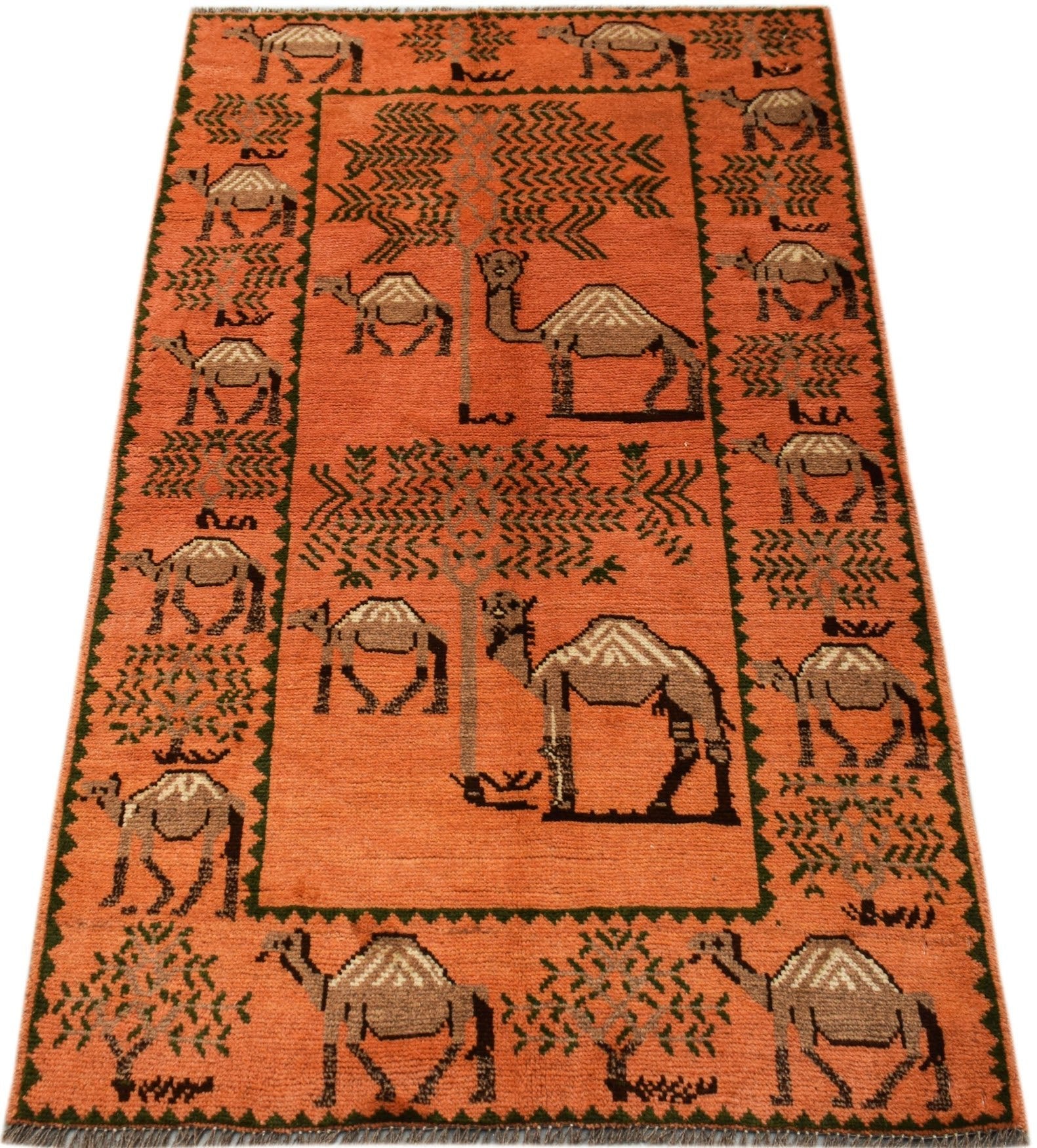 An orange hand-knotted Afghan wool rug featuring a repeating pattern of camels and trees.