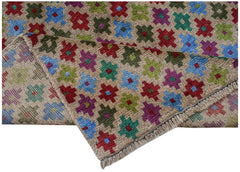 A handmade Afghan Pashm rug featuring a repeating pattern of colorful geometric floral motifs.