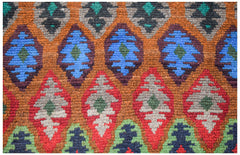 Handmade Afghan wool rug featuring a repeating diamond pattern in blue, red, and green tones.