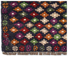 Handmade Afghan Pashm rug featuring a dark blue field with a repeating pattern of colorful motifs.
