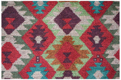 Handmade Afghan wool rug featuring a geometric diamond pattern in red, brown, green, and ivory.