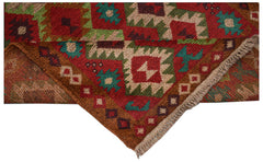 A handmade Afghan Pashm rug featuring a geometric tribal pattern in red, brown, and blue tones.