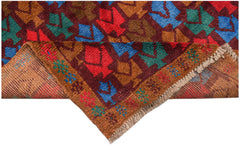 Handmade Afghan Pashm rug featuring a geometric tribal pattern in red, blue, and brown wool.
