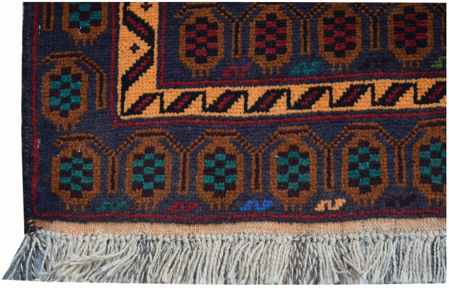 A handmade Afghan wool rug featuring a dark blue field with repeating geometric motifs and fringe.