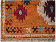 Handmade Afghan Pashm rug featuring tribal geometric patterns in red, blue, and ivory on orange.