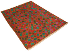 Handmade Afghan Pashm rug featuring a repeating geometric floral pattern in red, teal, and purple.