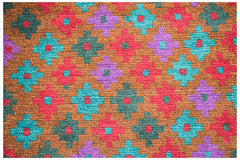 Handmade Afghan wool rug featuring a repeating geometric pattern in red, teal, purple, and brown.