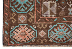 A handmade Afghan Pashm rug featuring geometric floral motifs in blue, orange, and brown.