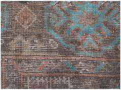 A close-up of a handmade Afghan Pashm rug featuring geometric patterns in brown, blue, and orange.