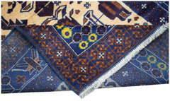 A handmade Afghan Pashm rug featuring a dark blue border with floral motifs and geometric patterns.