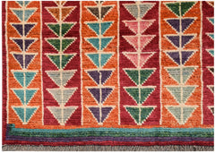 Hand-knotted Afghan wool rug featuring vertical stripes of colorful geometric triangle patterns.