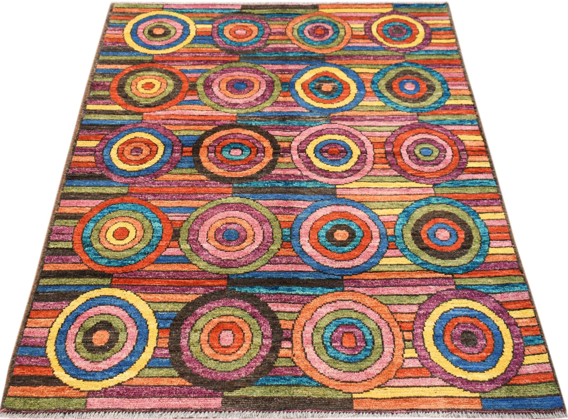 A hand-knotted Afghan wool rug featuring a vibrant, multicolored pattern of concentric circles.