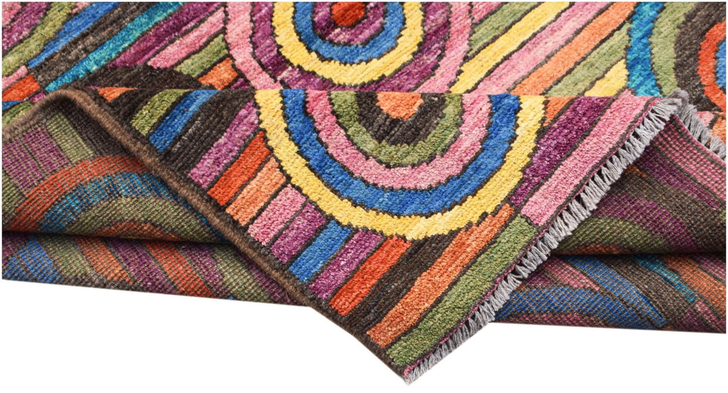 A hand-knotted Afghan wool rug featuring vibrant, multicolored concentric circles and stripes.