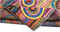 A hand-knotted Afghan wool rug featuring vibrant, multicolored concentric circles and stripes.