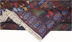 A handmade Afghan wool rug featuring a dark blue field with geometric patterns and fringe ends.