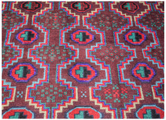 Handmade Afghan Pashm rug featuring a geometric pattern in dark red, blue, and green wool.