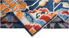 A hand-knotted Afghan wool rug featuring bold geometric floral patterns in blue, orange, and red.