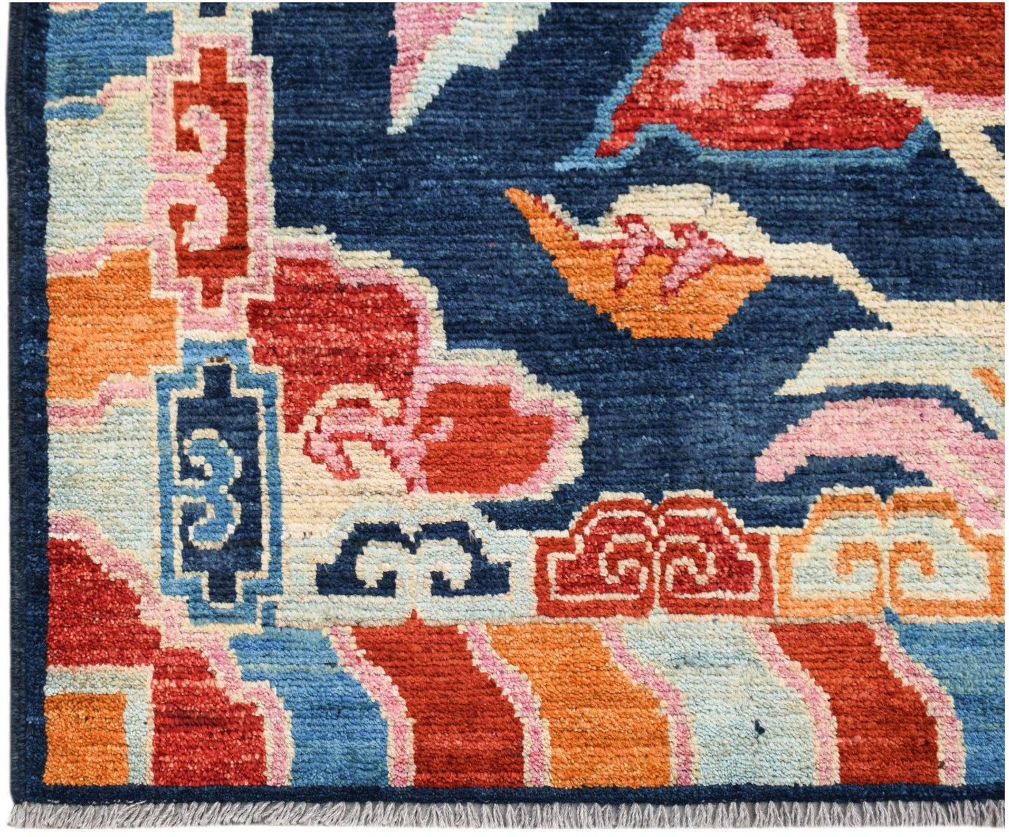 A hand-knotted Afghan wool rug featuring bold geometric patterns in blue, red, and orange.