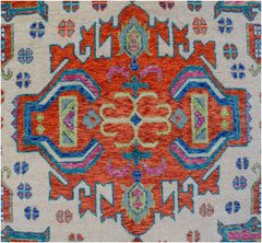 Handmade Afghan wool rug featuring a vibrant orange central medallion with blue and pink accents.