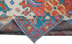 A handmade Afghan wool rug featuring a vibrant tribal pattern in orange, blue, and pink tones.