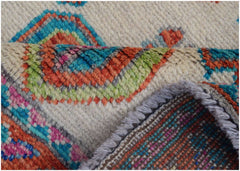 A close-up of a handmade Afghan wool rug featuring colorful tribal patterns on a cream background.