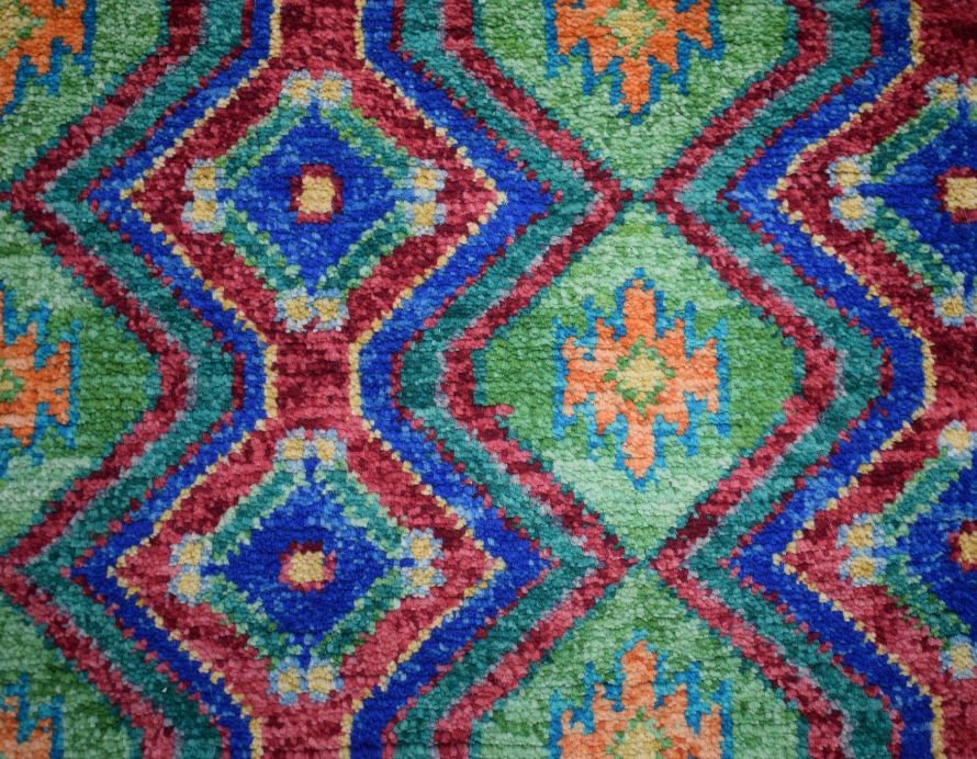 Handmade Afghan wool rug featuring a vibrant geometric diamond pattern in blue, green, and orange.