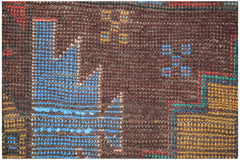 A close-up of a handmade Afghan Pashm rug featuring geometric blue and yellow patterns on brown wool.
