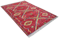 A hand-knotted Afghan wool rug featuring a red field with geometric diamond patterns and fringe.