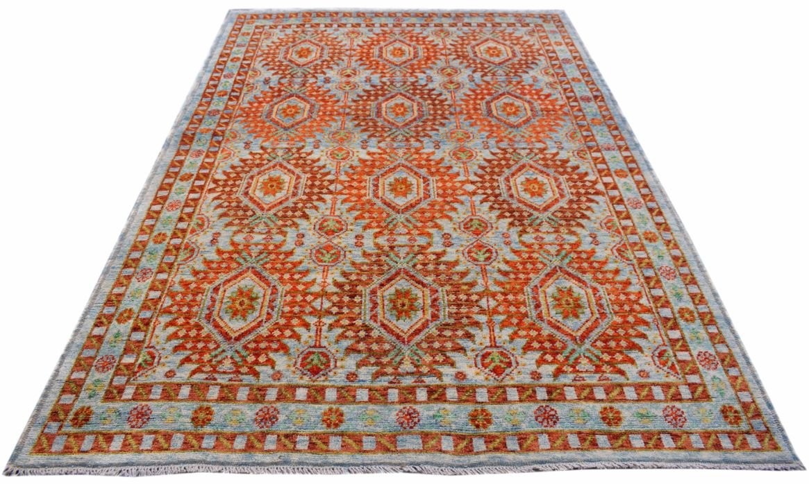 Handmade Afghan Pashm rug featuring a repeating geometric pattern in orange and light blue.