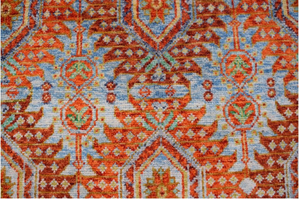 Handmade Afghan wool rug featuring a vibrant orange and blue geometric tribal pattern.