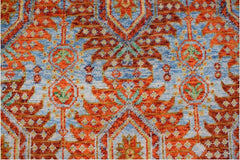 Handmade Afghan wool rug featuring a vibrant orange and blue geometric tribal pattern.