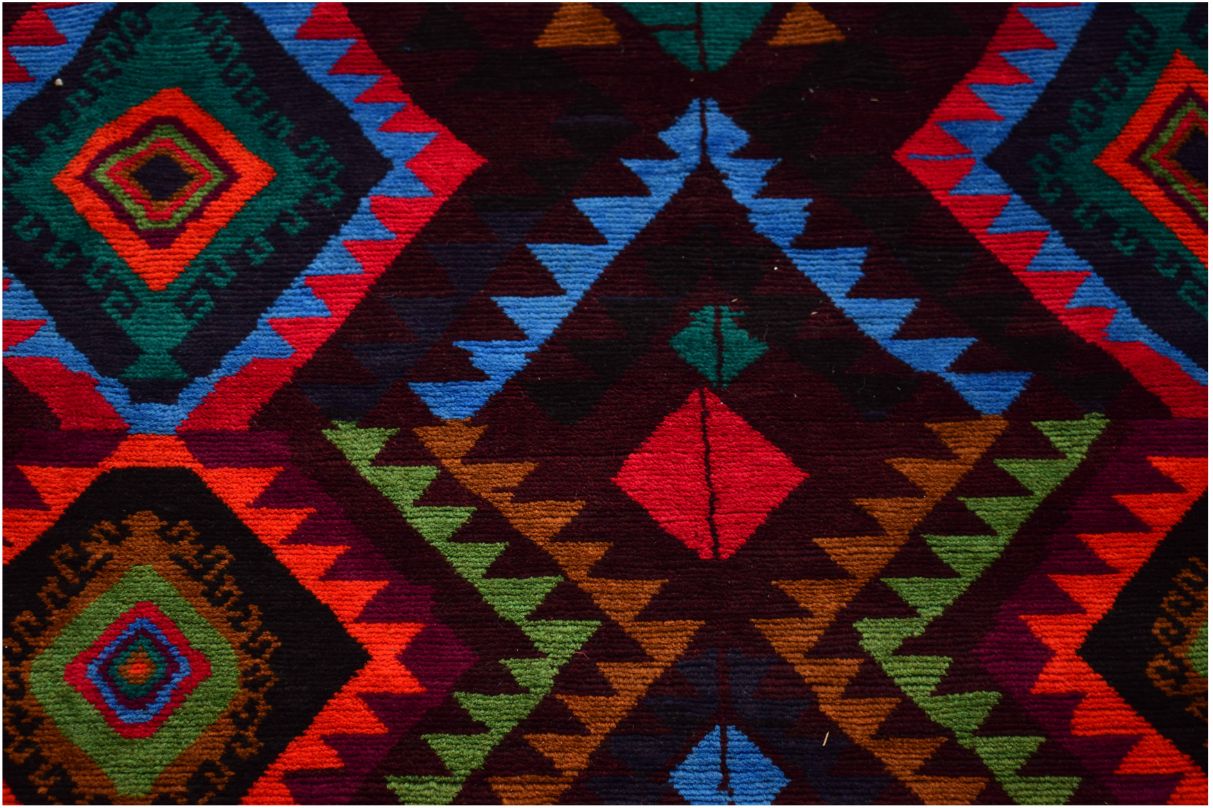 Handmade Afghan wool rug featuring a vibrant geometric diamond pattern in red, blue, and green.