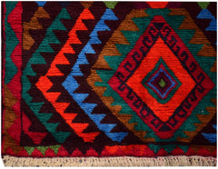 A handmade Afghan wool rug featuring a vibrant geometric diamond pattern in red, blue, and green.