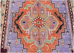 A handmade Afghan wool rug featuring a geometric orange medallion on a purple field.