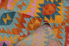 A handmade Afghan wool rug featuring a vibrant geometric pattern in blue, orange, and pink.
