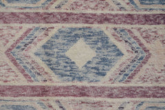 A handmade Afghan wool rug featuring a geometric diamond pattern in shades of blue and mauve.