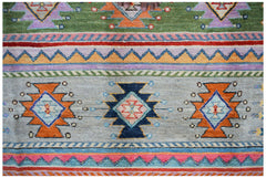 Handmade Afghan wool rug featuring colorful geometric tribal patterns on a light gray background.