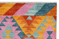 Handmade Afghan Pashm rug featuring a vibrant geometric pattern in orange, pink, and blue wool.
