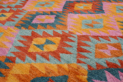 Handmade Afghan wool rug featuring a colorful geometric pattern in pink, orange, and blue.