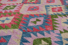 Handmade Afghan wool rug featuring a colorful geometric pattern in pink, blue, and green.