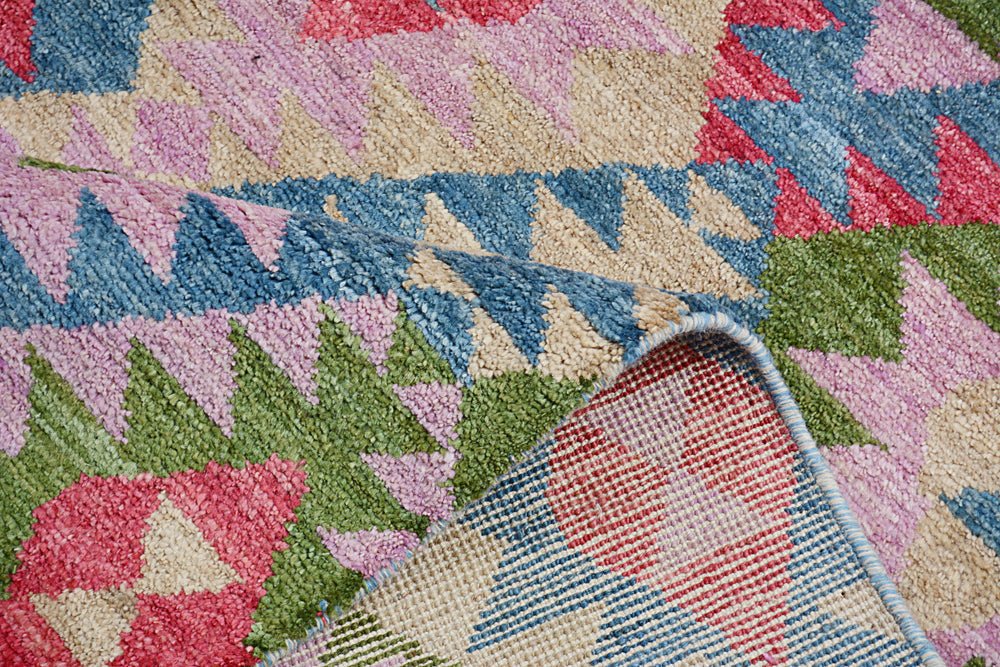 A handmade Afghan wool rug featuring a colorful geometric pattern with a plush pile texture.