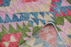 A handmade Afghan wool rug featuring a colorful geometric pattern with a plush pile texture.