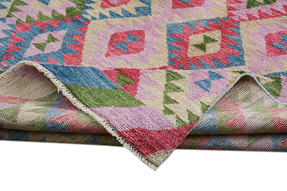 A handmade Afghan wool rug featuring a colorful geometric pattern folded to show its texture.