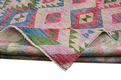 A handmade Afghan wool rug featuring a colorful geometric pattern folded to show its texture.