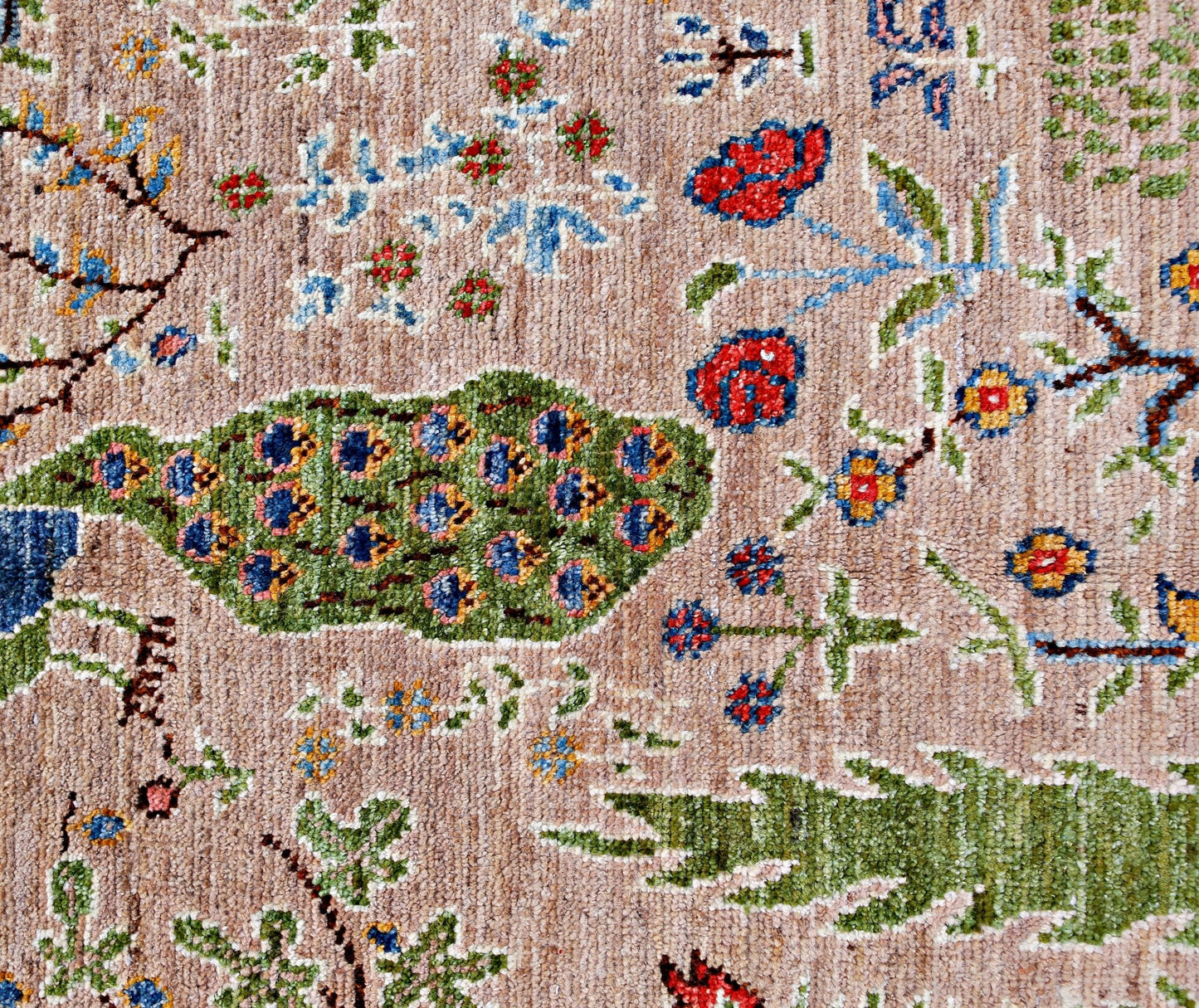 A handmade Afghan Pashm rug featuring a detailed floral and peacock motif on a tan wool background.