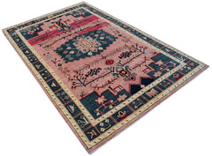 Handmade Afghan wool rug featuring a pink field with a central blue medallion and tribal motifs.